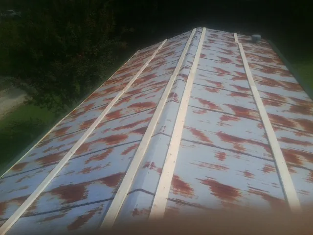 Rusted metal roof panels with new wood purlins before replacement — Storm Damage Roof Repair in Nielsville by Roofing Brothers