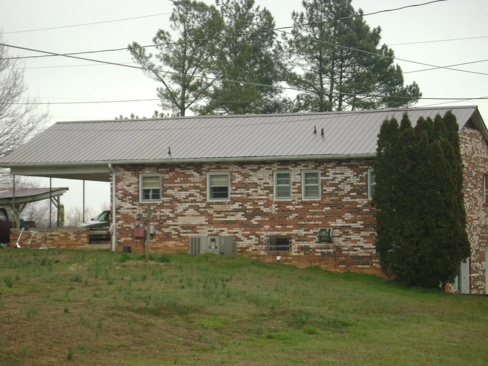 Gray metal roof on a brick split level home with a carport in Nielsville