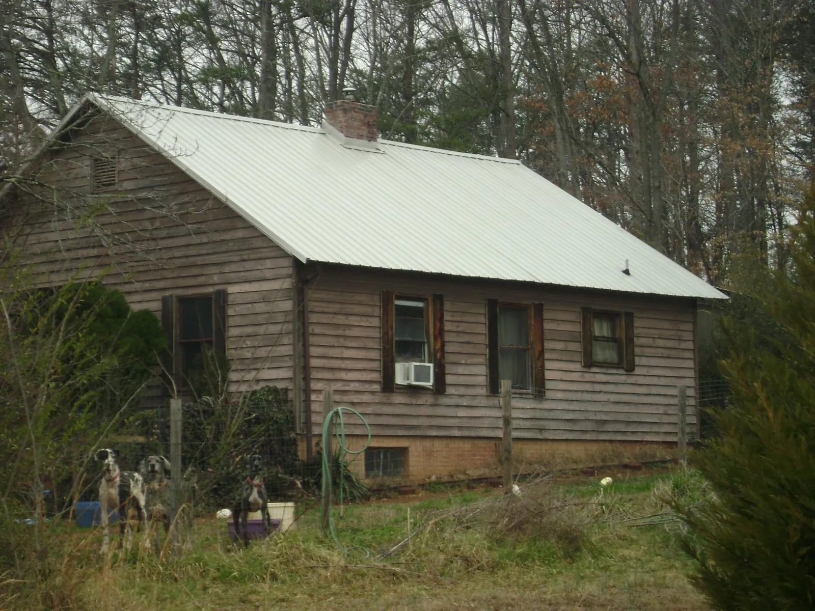 White metal roof on an old wood sided farmhouse, from a Metal Roof Installation job in Nielsville